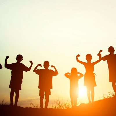 children-s-silhouettes-showing-muscles-sunset